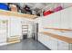 Functional garage with epoxy floors, white cabinets, and shelving for organized storage at 5712 Runnel Way, Charlotte, NC 28215