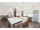 Open kitchen with island, white cabinets, stainless steel appliances, and pendant lighting at 5712 Runnel Way, Charlotte, NC 28215