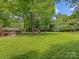 Expansive backyard with lush lawn, mature trees, wooden deck, and a play set providing ample outdoor enjoyment at 5817 Portburn Rd, Charlotte, NC 28211