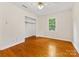 Bedroom features hardwood floors, closet, and natural light from a large window at 5817 Portburn Rd, Charlotte, NC 28211
