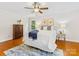 Cozy bedroom featuring a ceiling fan, a bed with a blue throw, and hardwood flooring at 5817 Portburn Rd, Charlotte, NC 28211