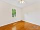 Cozy bedroom featuring hardwood floors and a window that invites natural light, creating a peaceful atmosphere at 5817 Portburn Rd, Charlotte, NC 28211