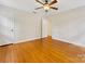 Spacious bedroom with hardwood floors, a ceiling fan and white trim throughout at 5817 Portburn Rd, Charlotte, NC 28211