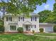 Charming two-story home featuring a well-manicured lawn, attached garage, and inviting front entrance at 5817 Portburn Rd, Charlotte, NC 28211