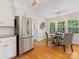 Kitchen/breakfast nook features stainless steel refrigerator, white cabinets, and backyard views at 5817 Portburn Rd, Charlotte, NC 28211