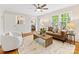 Cozy living room with hardwood floors, a ceiling fan, and large windows with backyard views at 5817 Portburn Rd, Charlotte, NC 28211