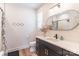 Well-lit bathroom featuring a modern vanity, decorative mirror, and a bathtub with a shower at 602 Kames Nw Ct, Conover, NC 28613