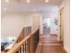 Upstairs hallway with wood floors and black metal railings leading to the bedrooms at 602 Kames Nw Ct, Conover, NC 28613