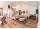 Open-concept living space featuring stairs, comfortable seating, hardwood floors, and ample natural light at 602 Kames Nw Ct, Conover, NC 28613