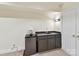Basement bar featuring dark cabinetry, a sink, small refrigerator and nearby closet at 6645 Gaywind Dr, Charlotte, NC 28226