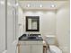 Bathroom with modern vanity, dark countertop, framed mirror, and decorative lighting at 6645 Gaywind Dr, Charlotte, NC 28226