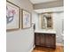 Bathroom features dark cabinets, framed mirrors, white countertop, and hardwood floors at 6645 Gaywind Dr, Charlotte, NC 28226