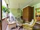 Inviting covered porch with wicker furniture and glass-top table for relaxing and entertaining at 6645 Gaywind Dr, Charlotte, NC 28226