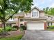 Charming home featuring an attached two car garage with brick accents and mature landscaping at 6645 Gaywind Dr, Charlotte, NC 28226