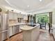 Bright kitchen boasts stainless steel appliances, stone countertops, and island with a dining area that opens to a deck at 6645 Gaywind Dr, Charlotte, NC 28226