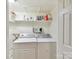 Functional laundry room equipped with modern washer, dryer, and shelving for storage of detergents at 6645 Gaywind Dr, Charlotte, NC 28226