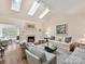 Bright living room featuring a fireplace, skylights, and comfortable seating, perfect for relaxing or entertaining guests at 6645 Gaywind Dr, Charlotte, NC 28226