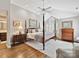 Spacious main bedroom with a four poster bed, hardwood floors and a large window at 6645 Gaywind Dr, Charlotte, NC 28226