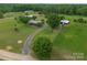 A house with a metal roof is framed by lush green trees and a long driveway at 6813 Rebel Rd, Marshville, NC 28103