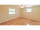 Cozy bedroom featuring hardwood floors and natural light from two windows at 6813 Rebel Rd, Marshville, NC 28103