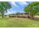 Inviting single-story home featuring a cozy front porch, manicured lawn, and mature shade trees at 6813 Rebel Rd, Marshville, NC 28103