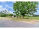 Large oak tree and a long gravel driveway compliment the landscape surrounding this charming home at 6813 Rebel Rd, Marshville, NC 28103