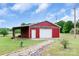 Exterior view of the large red storage building with an attached carport, featuring a new garage door and concrete floor at 6813 Rebel Rd, Marshville, NC 28103