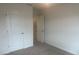 View of a simple bedroom space featuring neutral carpeting, white trim, and a door leading to a hall at 756 Gondola Ct # 127, Salisbury, NC 28144