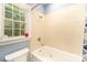 Bathroom features a tub/shower combination, cream ceramic tile, and a window that offers natural light and a view at 8300 Loma Linda Ln, Waxhaw, NC 28173
