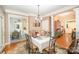 Bright dining area with elegant chandelier, hardwood floors, and views into the kitchen and main living space at 8300 Loma Linda Ln, Waxhaw, NC 28173