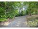 Scenic driveway leading through lush trees, offering a private and serene approach to the property at 8300 Loma Linda Ln, Waxhaw, NC 28173