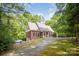 Scenic view of the brick home featuring a driveway and mature trees in a serene setting at 8300 Loma Linda Ln, Waxhaw, NC 28173