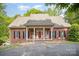 Charming brick home featuring a cozy front porch with rocking chairs and a red front door at 8300 Loma Linda Ln, Waxhaw, NC 28173