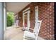 Inviting front porch with brick accents, rocking chairs, and a vibrant red front door at 8300 Loma Linda Ln, Waxhaw, NC 28173
