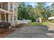 Spacious backyard with an exterior shed, partial privacy fence, mature trees, and a paved driveway at 836 Meadowlark Dr, Rock Hill, SC 29732