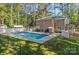 A sprawling backyard with a fenced in pool area, patio seating, mature trees, and lush green grass at 836 Meadowlark Dr, Rock Hill, SC 29732