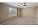 Cozy bedroom with neutral carpet, ceiling fan, and a large window with wooded views at 836 Meadowlark Dr, Rock Hill, SC 29732