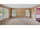 Neutral living room featuring carpet, two windows with draperies, and adjacent doorway to a hallway at 836 Meadowlark Dr, Rock Hill, SC 29732