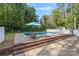 In-ground swimming pool with a surrounding patio and brick steps leading to a garden area at 836 Meadowlark Dr, Rock Hill, SC 29732
