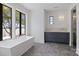 A modern bathroom offers a soaking tub beneath a picture window and a vanity with lake views at 8397 Ranger Island Marina Rd, Denver, NC 28037