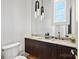 Stylish powder room featuring a modern vanity with marble countertop and unique pendant lighting at 8397 Ranger Island Marina Rd, Denver, NC 28037