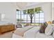 Sunlit bedroom with water views through large windows, complemented by elegant decor and furnishings at 8397 Ranger Island Marina Rd, Denver, NC 28037