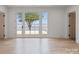 A bright bedroom features wood floors and a wall of windows and doors that look out to the lake at 8397 Ranger Island Marina Rd, Denver, NC 28037