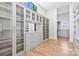 Expansive walk-in closet with custom cabinets, glass-front shelves, and ample storage solutions at 8397 Ranger Island Marina Rd, Denver, NC 28037