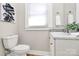 A well-lit half bathroom offers a white vanity, wood-look flooring, and gray walls at 908 W Airline Ave, Gastonia, NC 28052