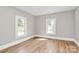 A bright bedroom features gray walls, wood-look floors, and two windows at 908 W Airline Ave, Gastonia, NC 28052