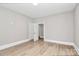 An empty bedroom has light gray walls, white trim, and wood-look vinyl flooring at 908 W Airline Ave, Gastonia, NC 28052
