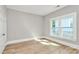 An empty bedroom offers wood-look floors, neutral paint, and a large window at 908 W Airline Ave, Gastonia, NC 28052
