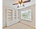 Cozy bedroom featuring a ceiling fan, built-in bookshelves, and a large window at 9723 Mattforest Cir, Charlotte, NC 28277