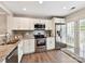 Well-lit kitchen featuring granite counters, stainless steel appliances, and hardwood flooring at 9723 Mattforest Cir, Charlotte, NC 28277